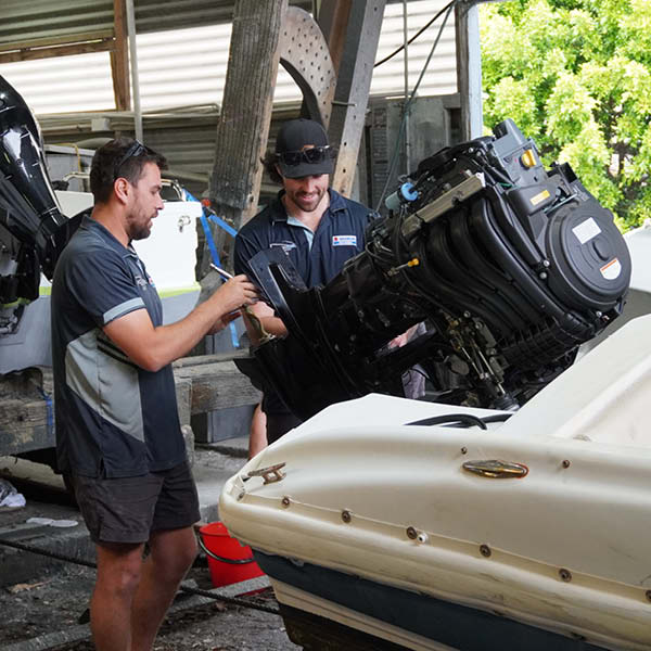 Team working on Suzuki Marine engine on slipway Team working on Suzuki Marine engine on slipway